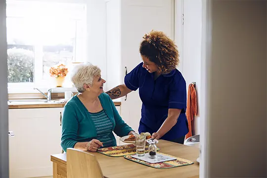 An elderly client being cared for by a support worker